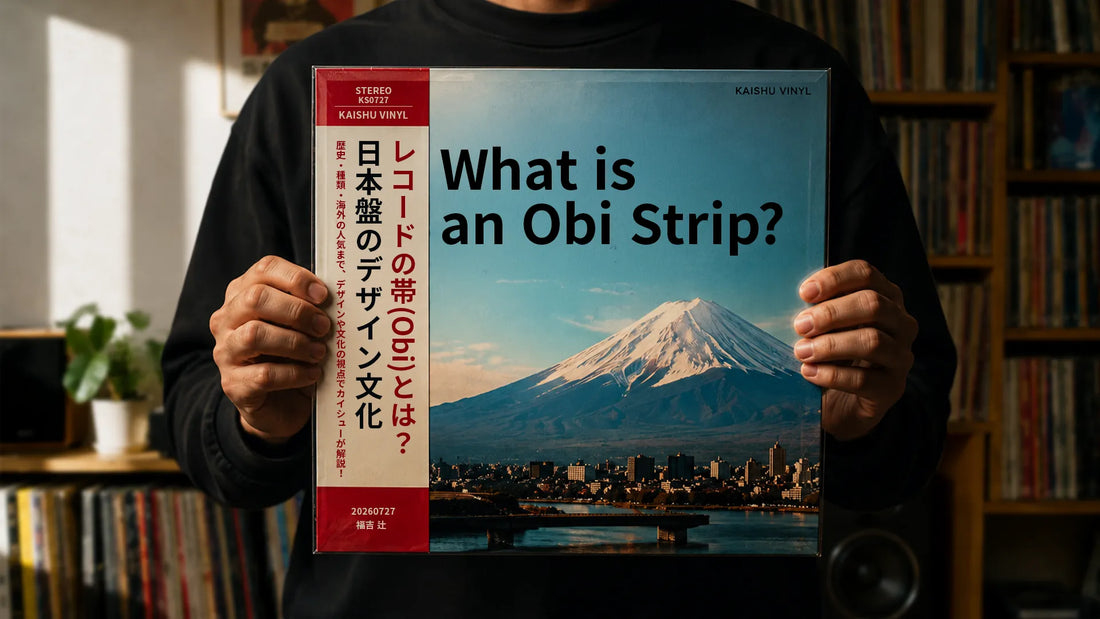 Person holding a vinyl record featuring Mount Fuji and a red Japanese obi strip.